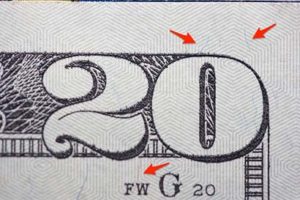 Showing red and blue security fibers embedded in $20 bill.