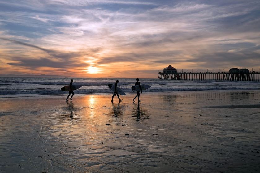 surfers walking in a beach