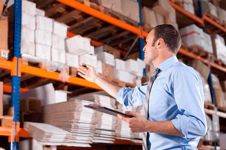 Employee managing inventory in warehouse.