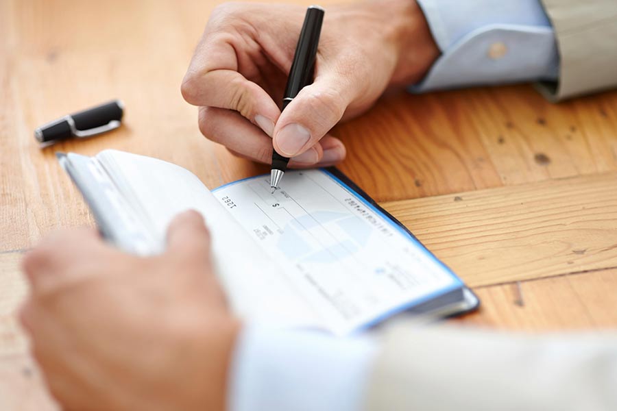 Man filling out a check.