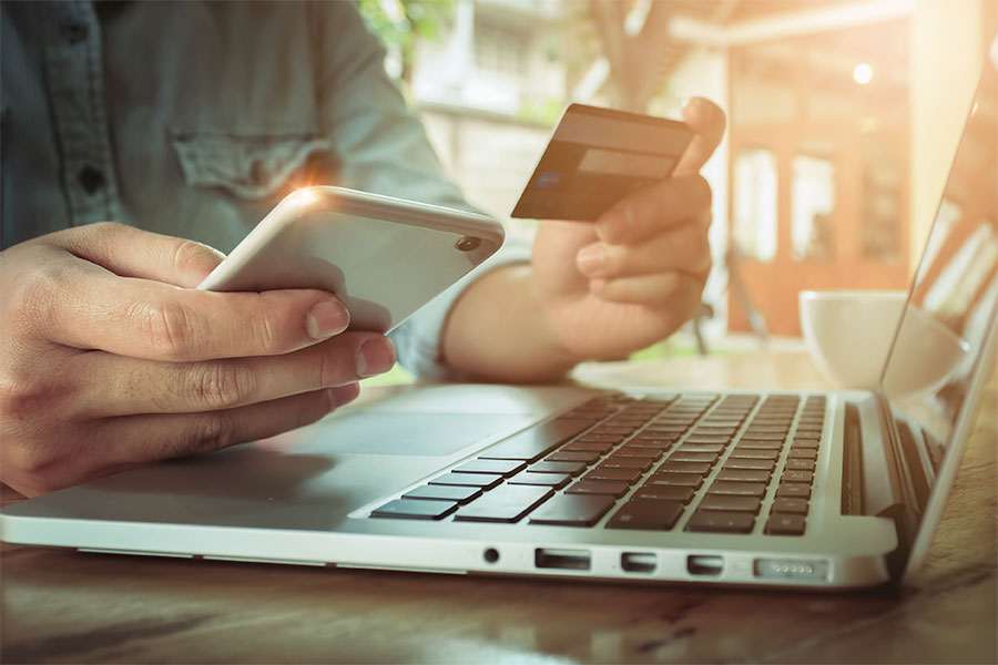 Guy holding credit card and phone.