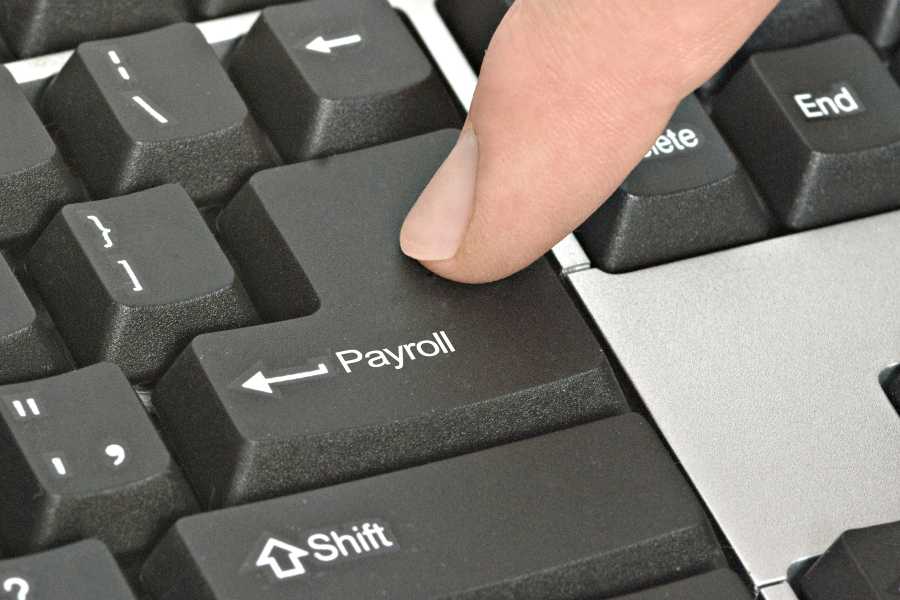 Pressing payroll key using an index finger.