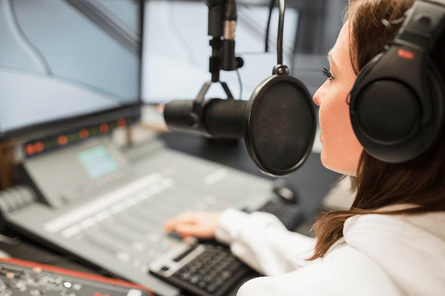 Female DJ works in a broadcast studio.