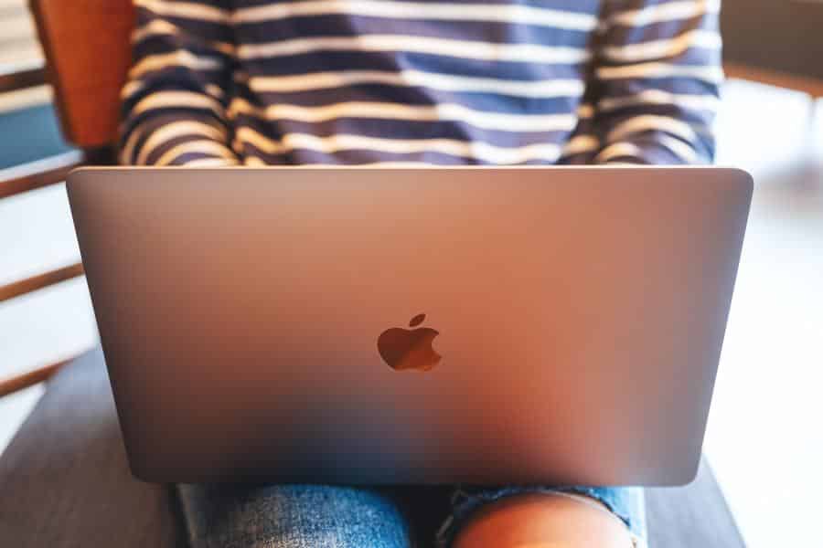 Girl wearing a striped jacket working on her Mac.