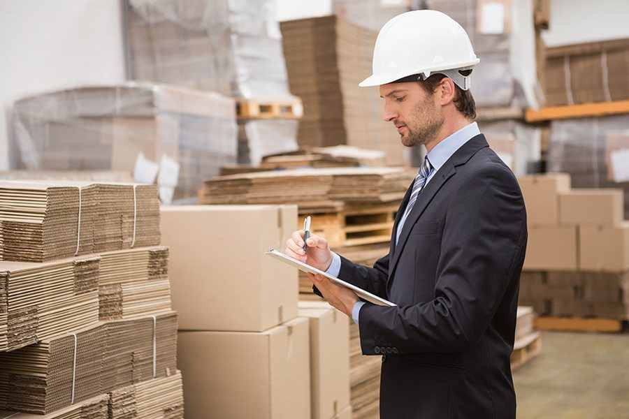 Man wearing a hard hat doing inventory.