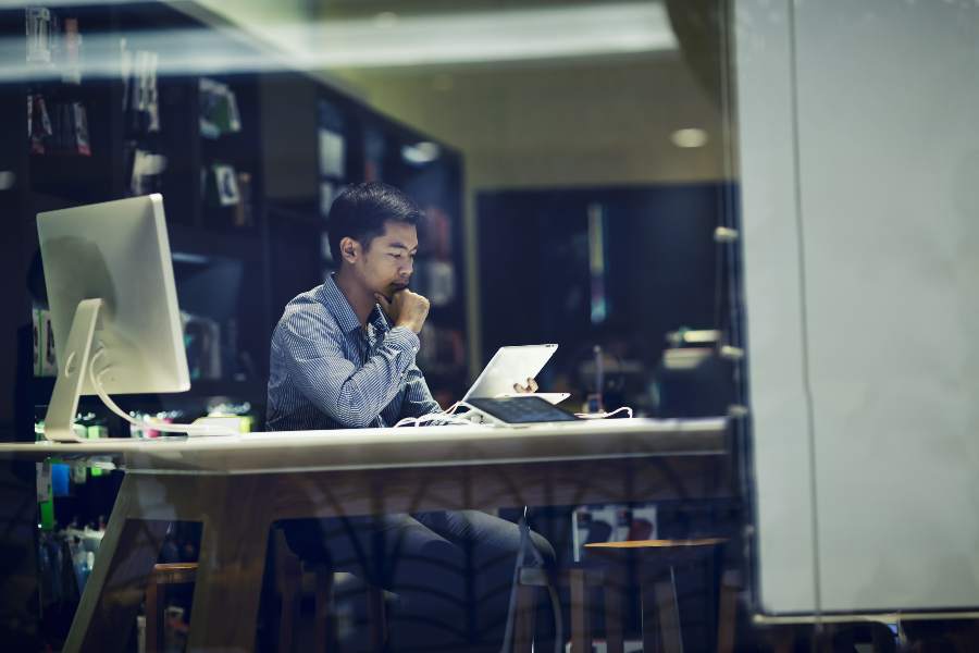 亚洲商人在会议室使用平板电脑和个人电脑。