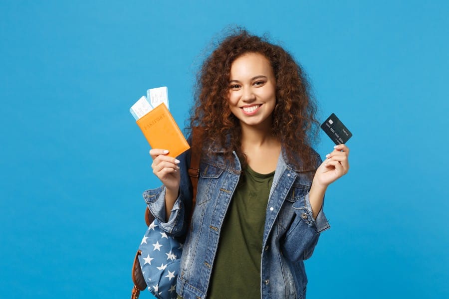 Young African girl holding a passport and a credit card.