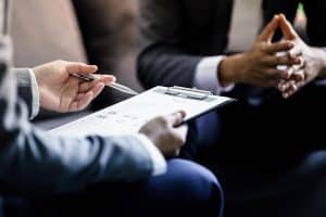 Businessman holding a clipboard while having a discussion.