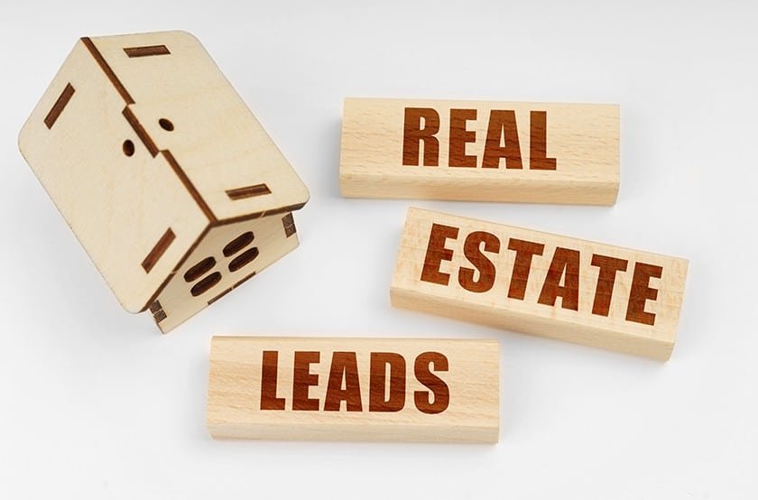 木屋模型和积木上写着“房地产领先”。