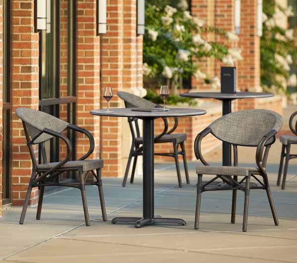 Bistro table and chairs on a sidewalk.