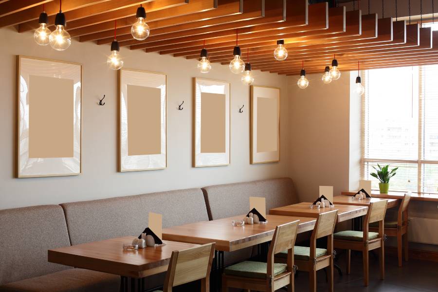 Empty restaurant tables with blank frames in the wall